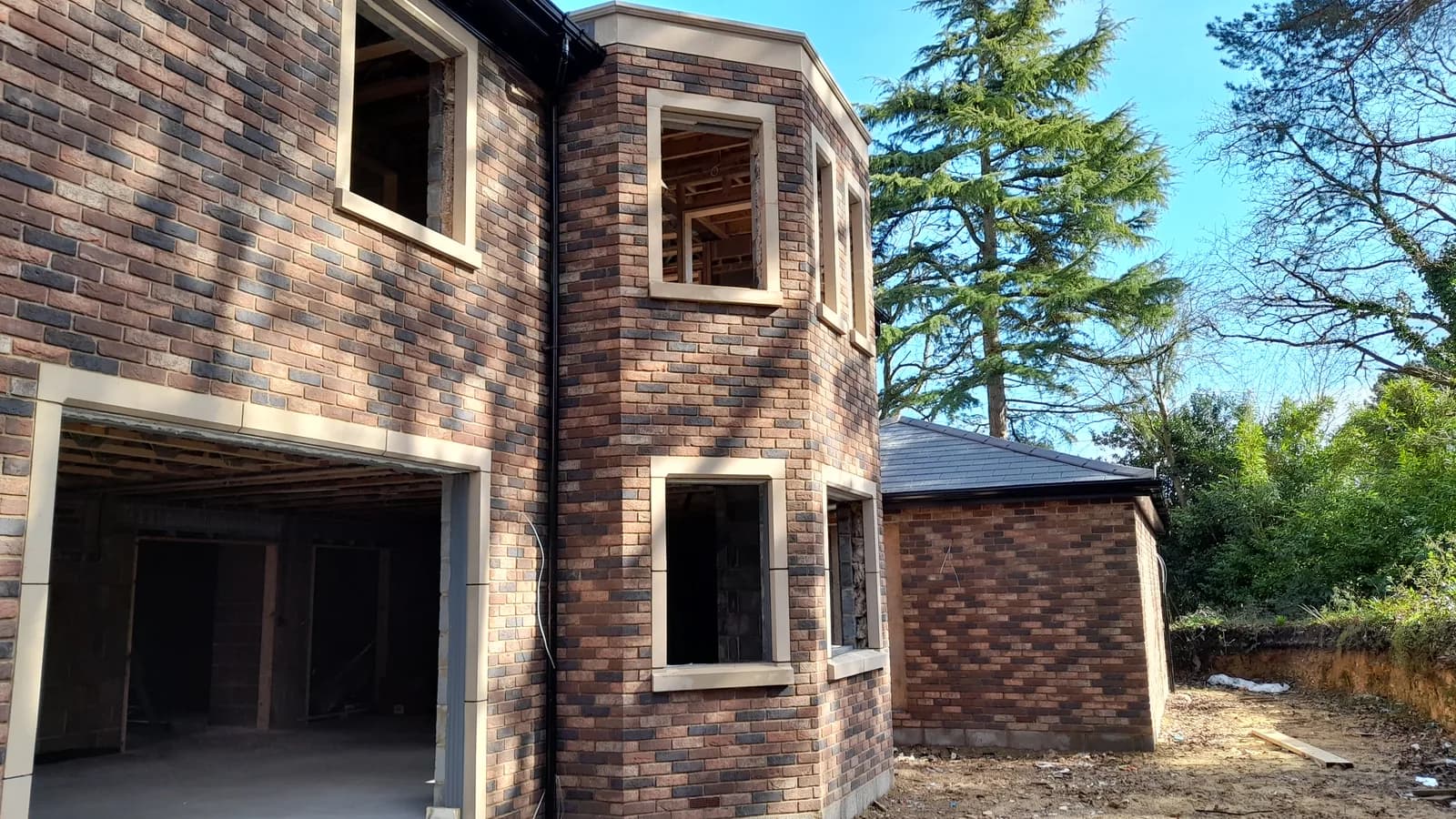 Brick building shell with unfinished window and garage openings