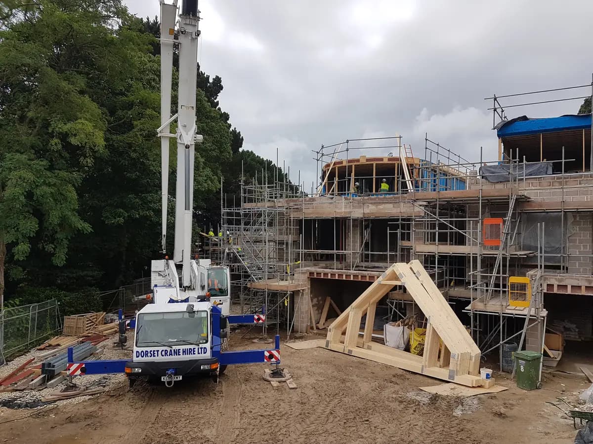 Dorset Crane Hire crane with scaffolded buildings and timber roof trusses