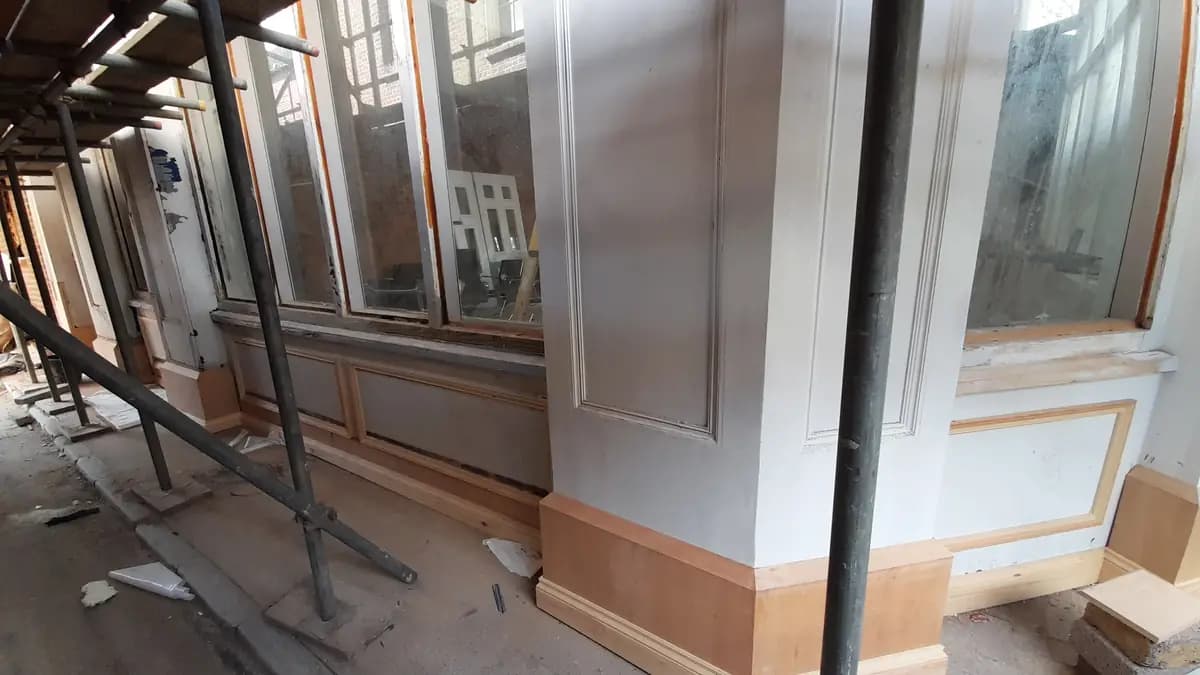 Facade restoration with scaffold, windows, trim and dusty walkway