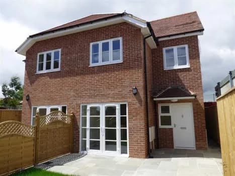 Finished brick house exterior with paving and fenced side access