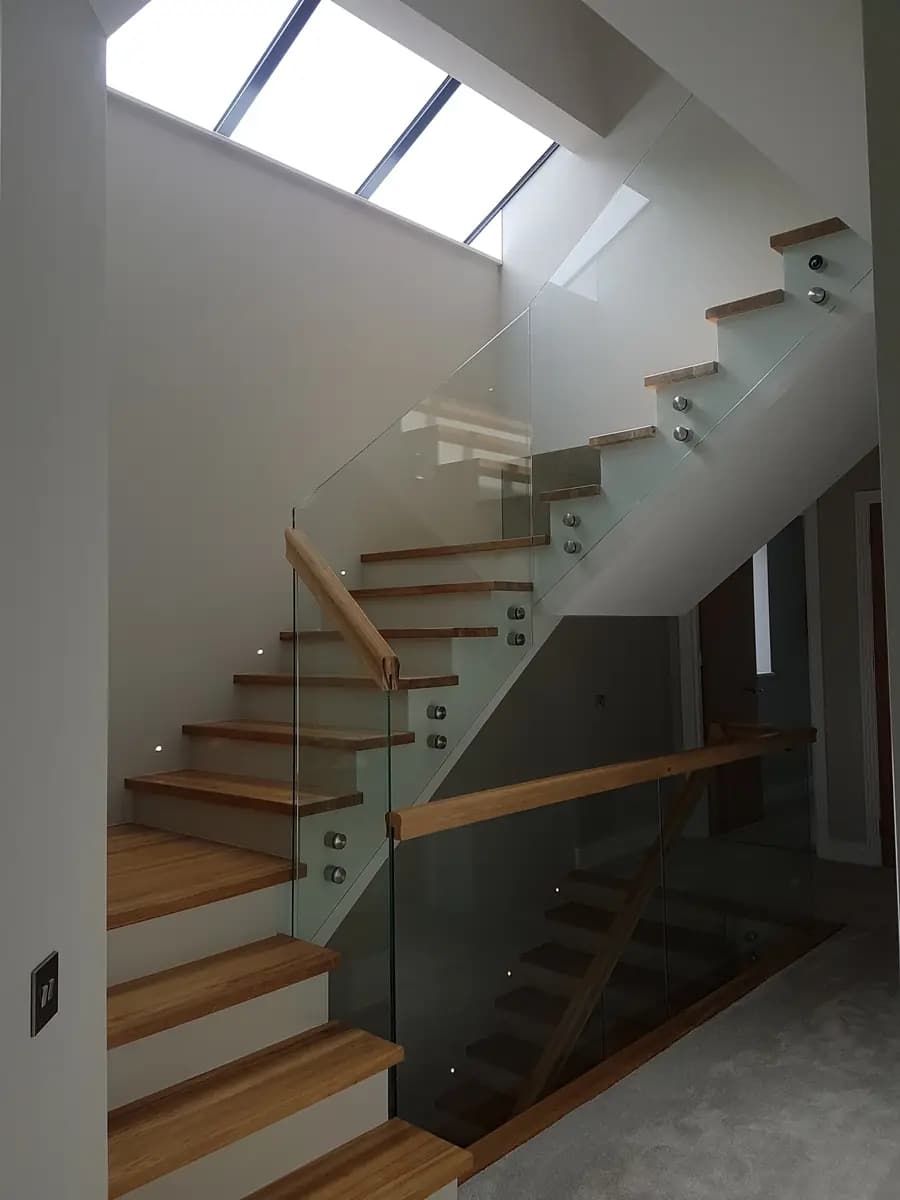 Modern finished stairwell with glass balustrade and large skylight