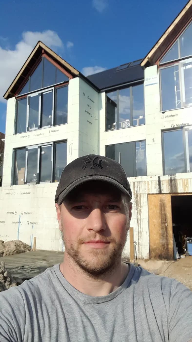 Josh on site in front of a large residential construction project