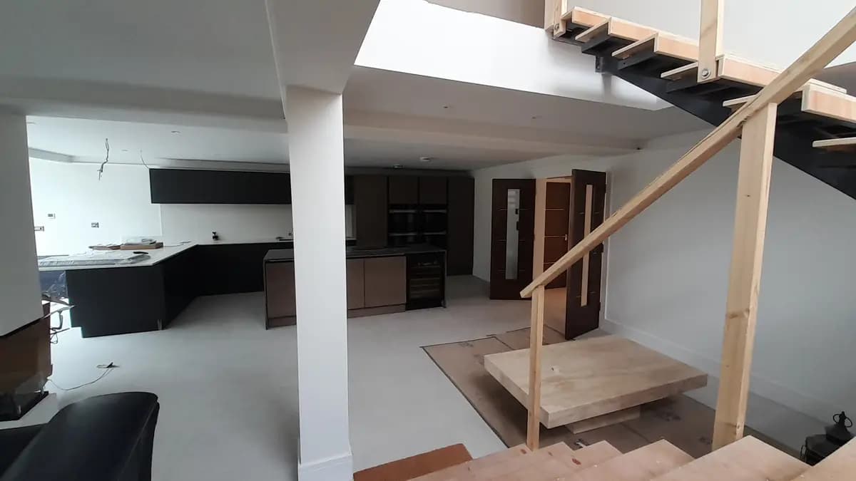 Modern kitchen and stairwell fit-out with exposed temporary railings