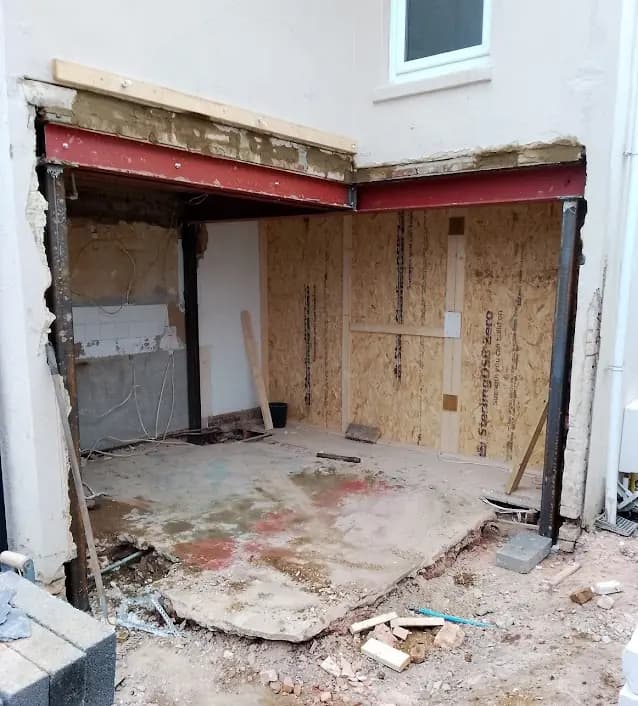 Large wall opening supported by red steel beams during renovation