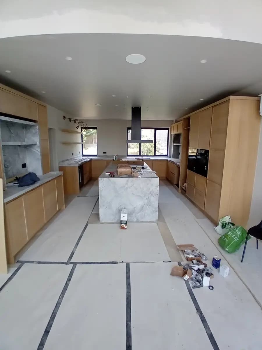 Modern marble kitchen installation with island, cabinets and construction materials
