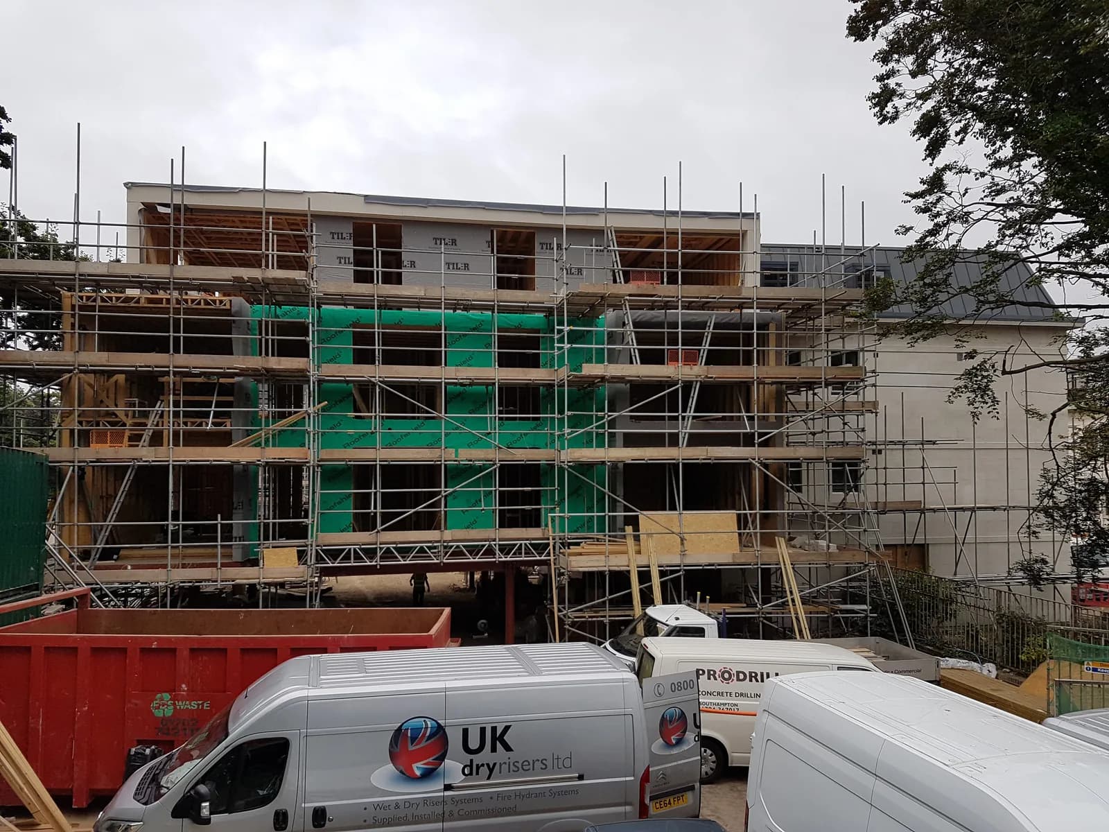 Multi-storey timber-frame building under construction with scaffolding