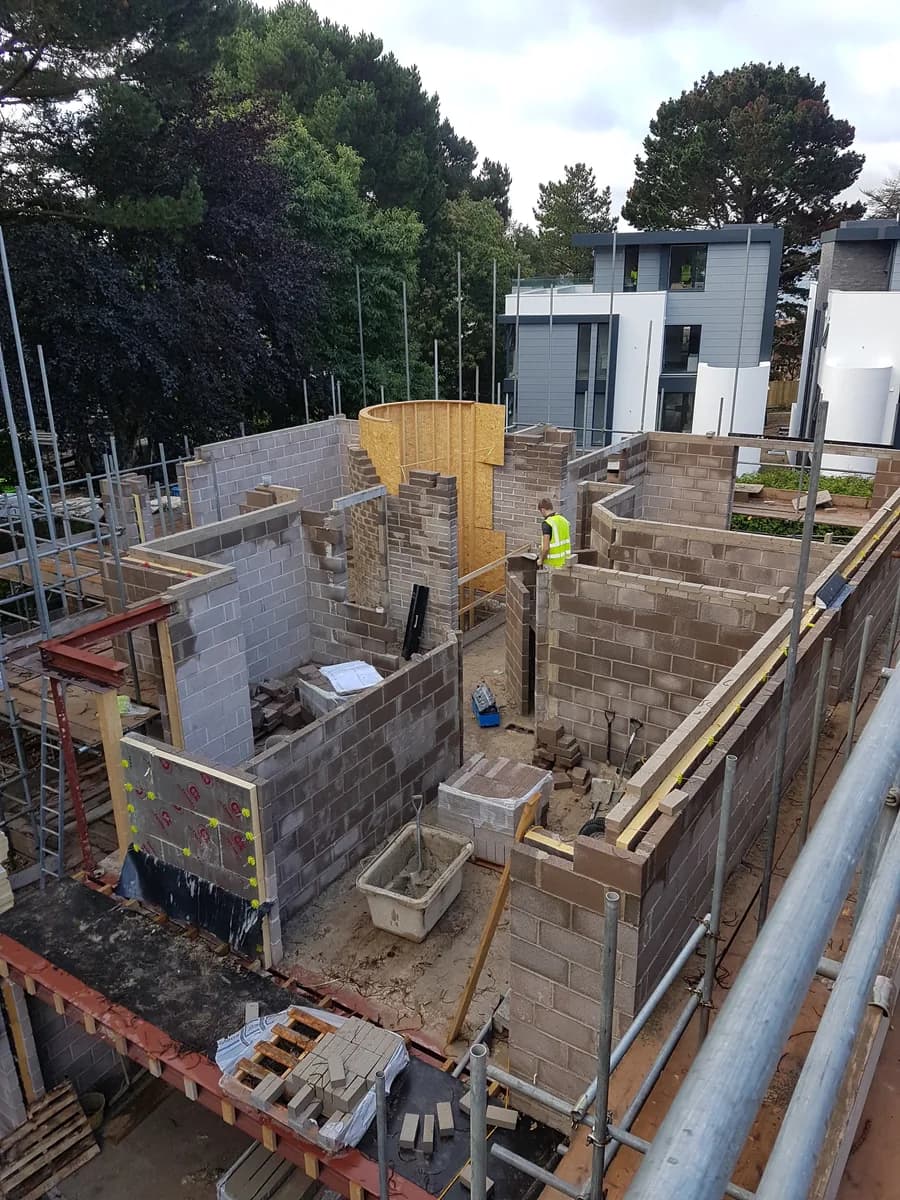 Multi-unit masonry construction with scaffolding and temporary timber formwork