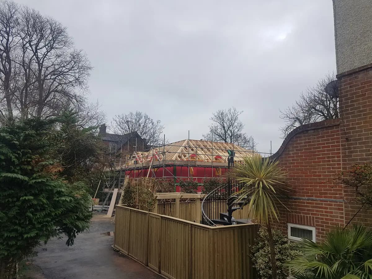 Residential roof trusses and scaffolding viewed from neighbouring garden