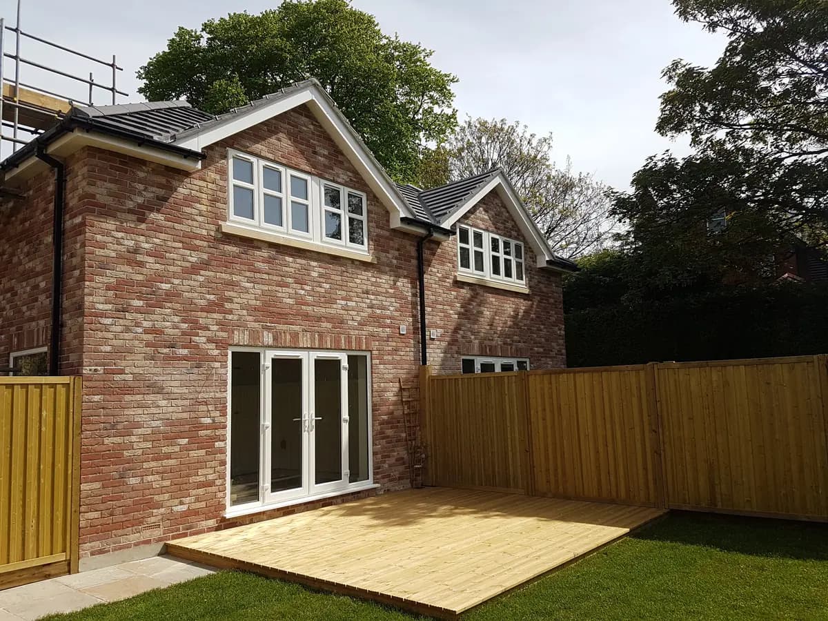 New brick house exterior with timber deck, fencing and some scaffold