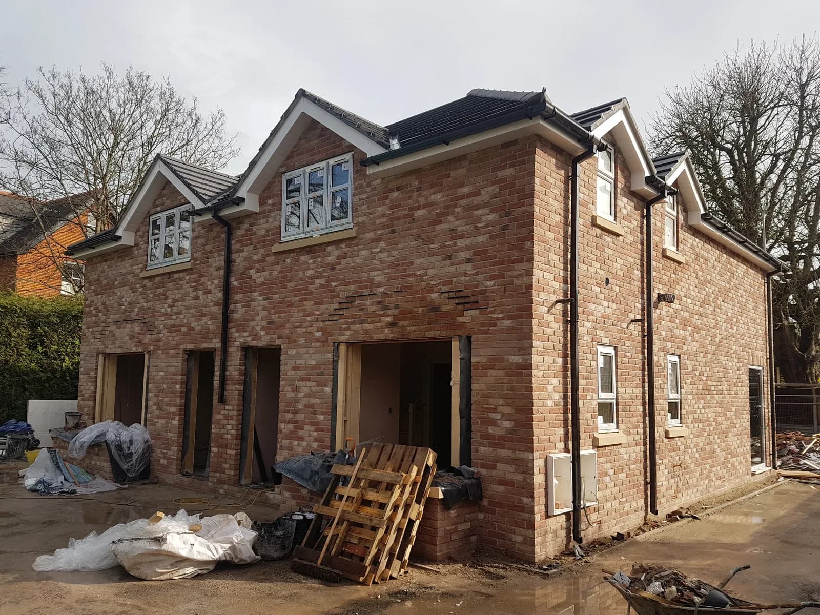 Row of new brick houses under construction with open lower entrances