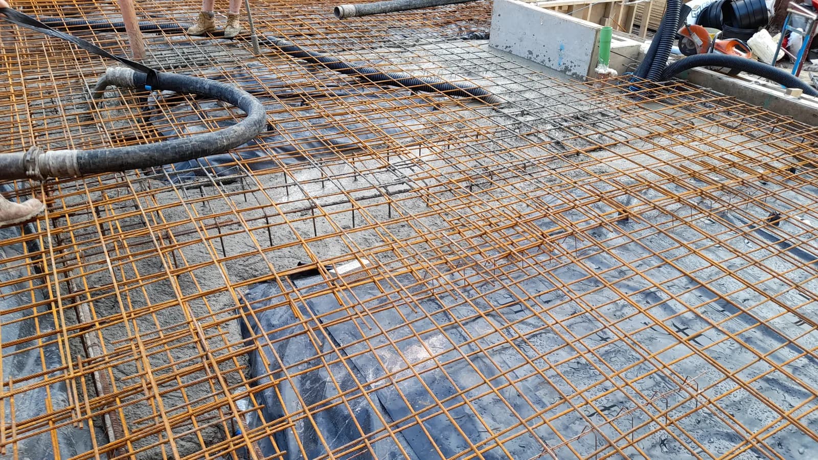 Reinforced concrete slab preparation with rebar and pump hose