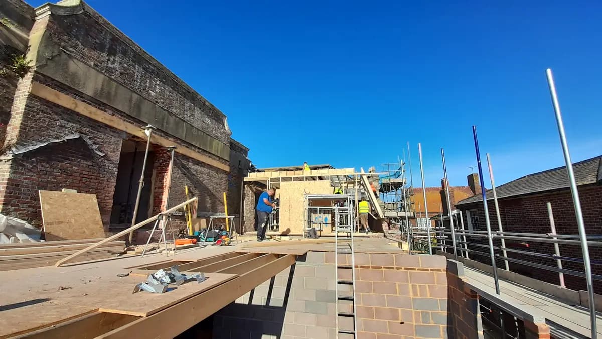 Rooftop renovation with scaffolding, timber framing and workers