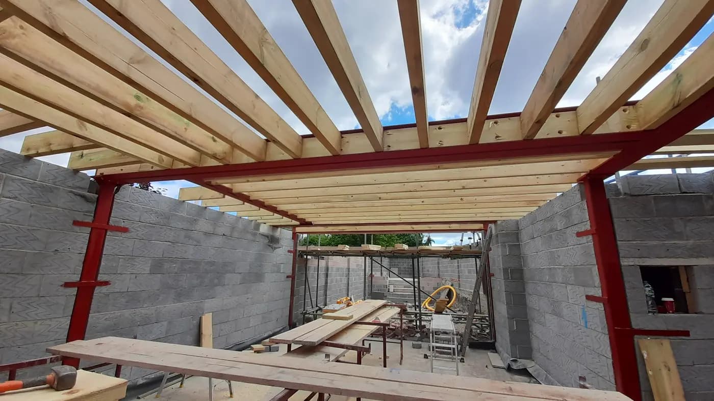 Open roof with timber joists on red steel and concrete blockwork