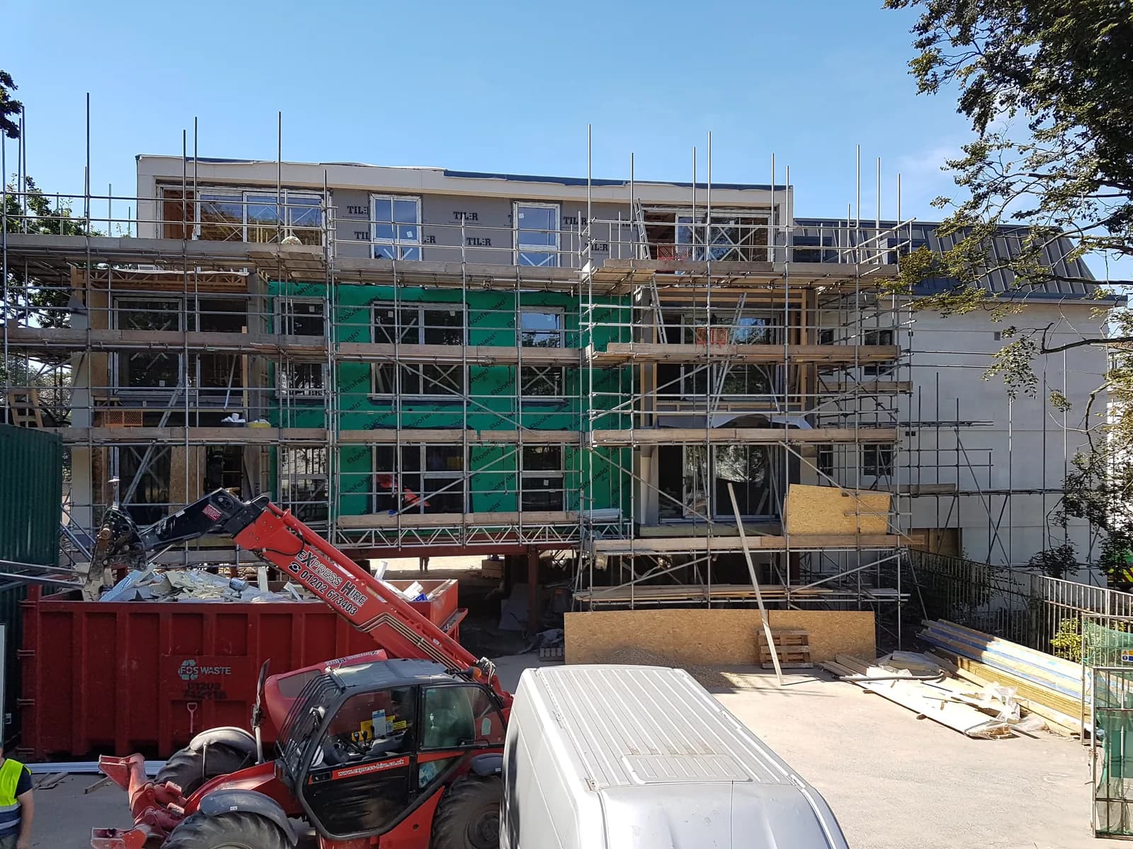 Scaffolded multi-storey building with window installation and facade works