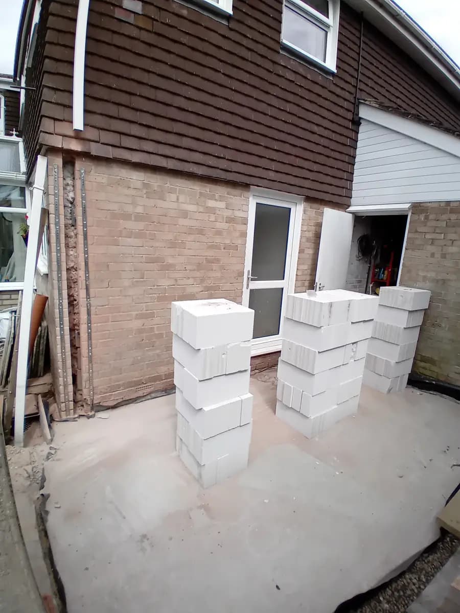 Side return construction with white blocks stacked beside existing house