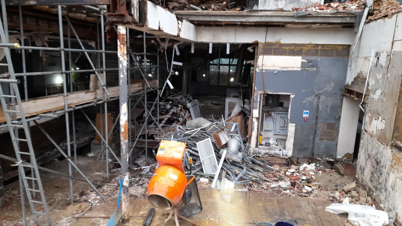 Stripped-out building interior with exposed frame and debris