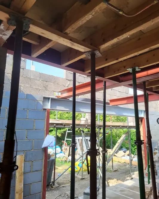 Temporary props supporting joists and steel beams inside a renovation opening