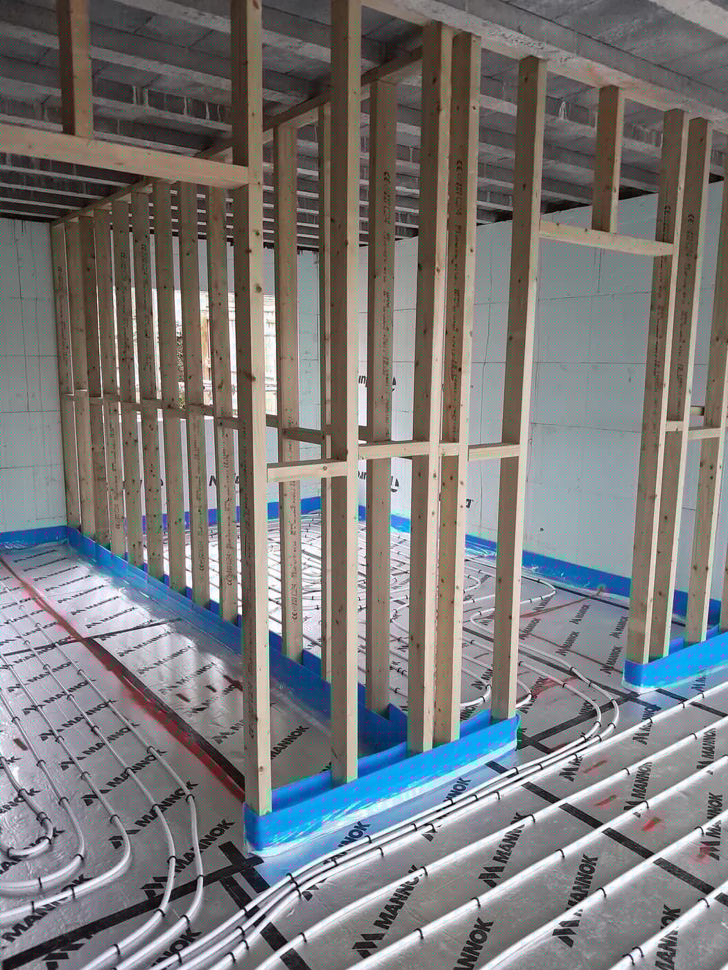 Timber studwork with reflective floor membrane and underfloor heating pipes
