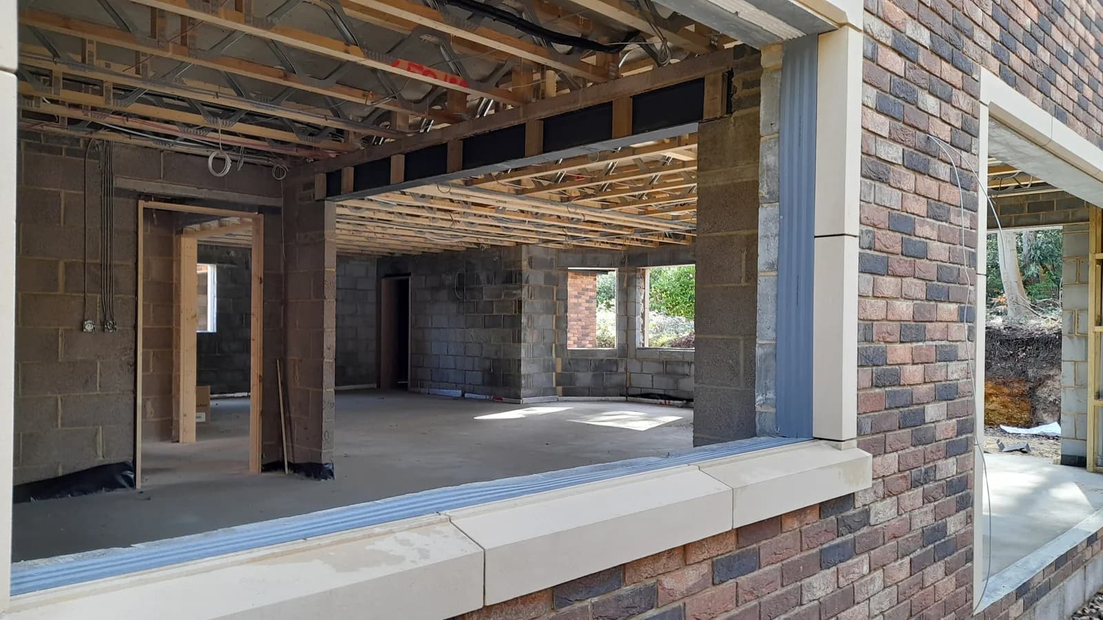 Unfinished interior with exposed wiring, timber and masonry