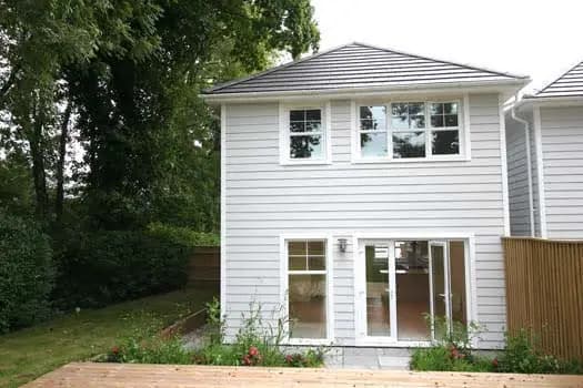 White-clad house with garden deck and patio doors