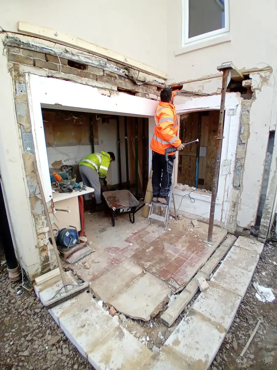 Workers forming a structural opening inside a property